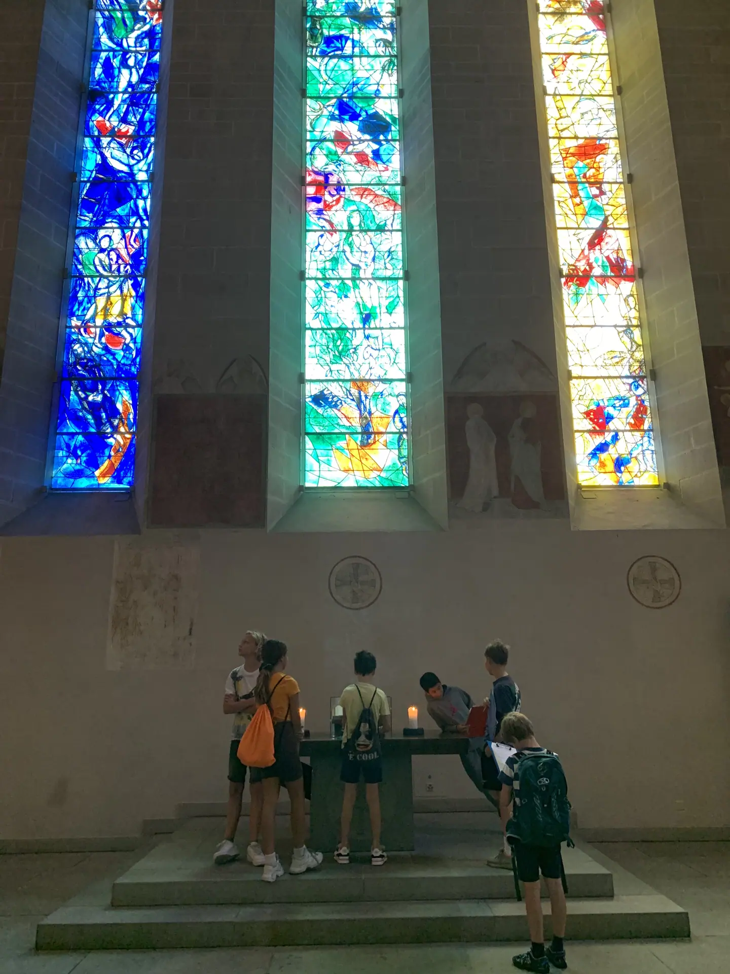 Ehrfürchtig bestaunen die Schü­le­rin­nen und Schü­ler die berühm­ten Kichen­fenster von Marc Chagall.