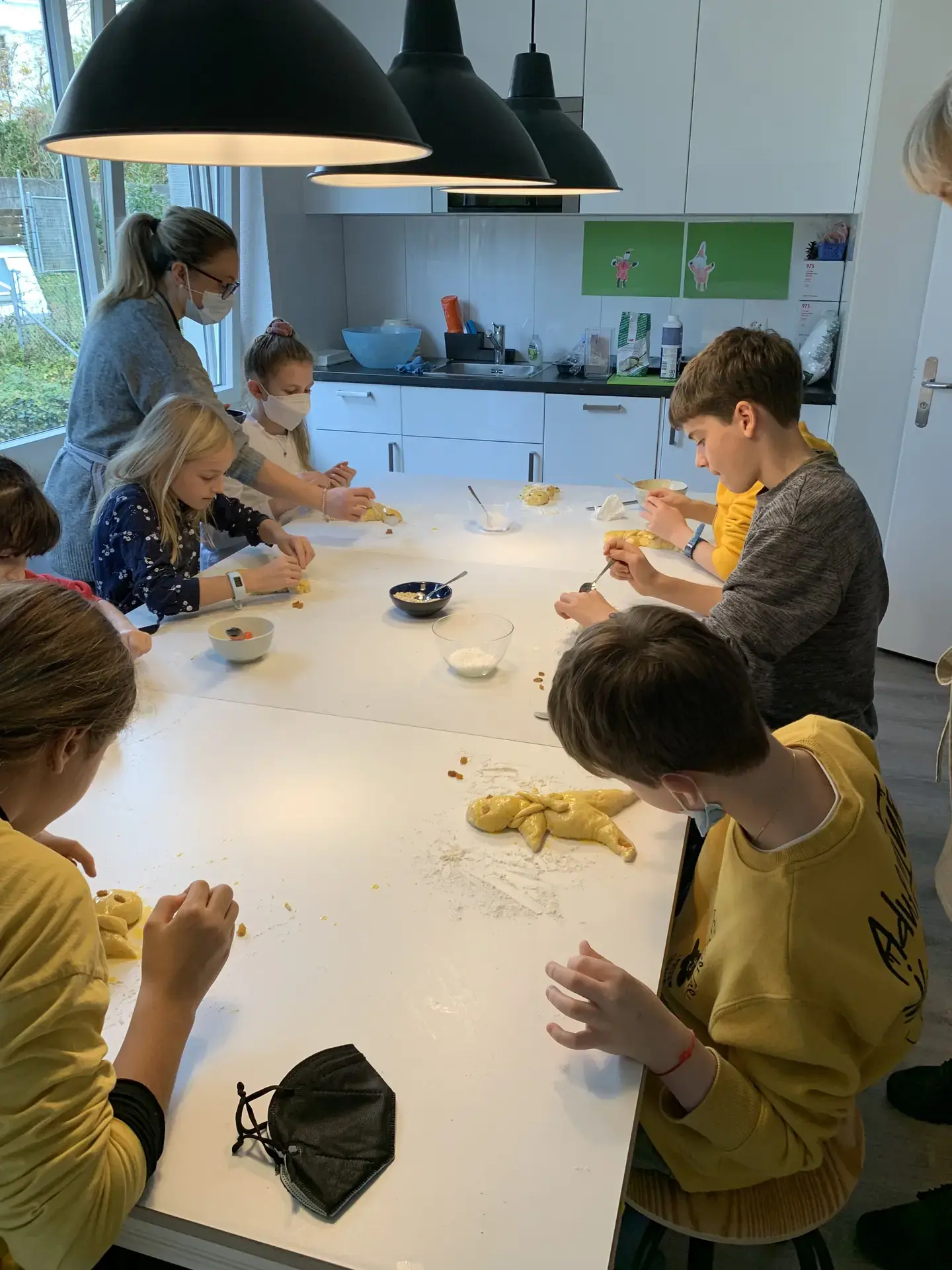 Nach der Anleitung unserer Köchin formen die Schülerinnen und Schüler ihre Grittibänzen.